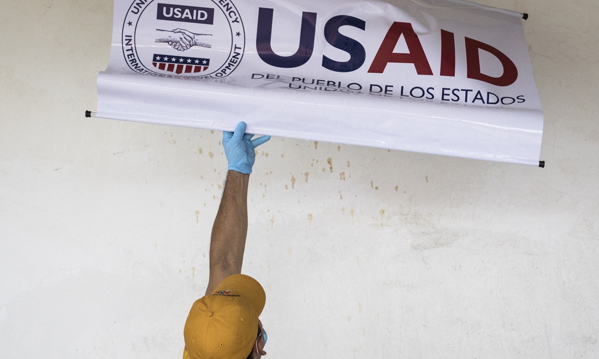 A staff is taking off a sign of the USAID in a community in Cucuta, Colombia, on February 9, 2019. Photo:AFP A staff is taking off a sign of the USAID in a community in Cucuta, Colombia, on February 9, 2019. Photo:AFP