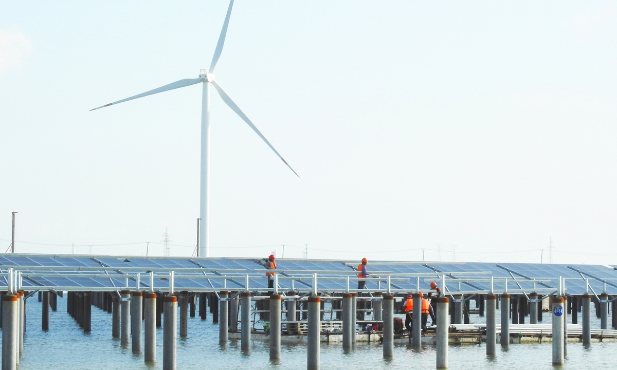 Workers install solar panels at a solar power plant in Lianyungang, East China's Jiangsu Province on Tuesday. The plant is being built over fish ponds, as part of an innovative photovoltaic demonstration projects. Once completed, it will have an installed capacity of 200 megawatts. Photo:cnsphoto
